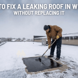 Man applying liquid butyl rubber coating on a flat roof in winter to fix leaks without replacing the roof.