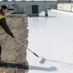 Close-up of a hand applying an EPDM roof repair tape.