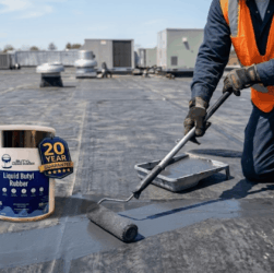 A close-up view of a professional roofer sealing a seam on a black EPDM rubber roof with a roller and seam tape to repair a leak.